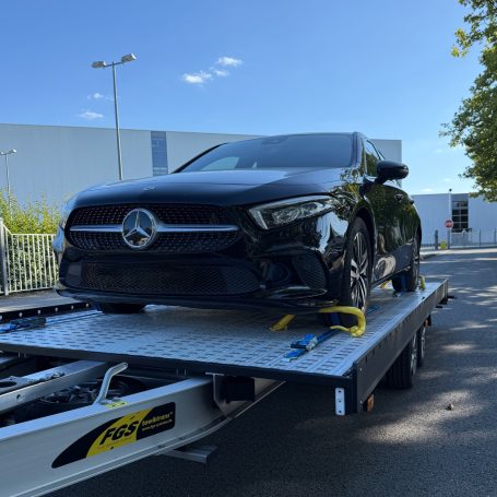 Frontansicht einer schwarzen Mercedes A-Klasse auf dem Transportanhänger von MHX Fahrzeugtransporte aus Gütersloh