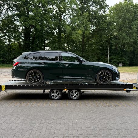 Seitenansicht des BMW M340d Touring auf dem Transportanhänger von MHX Fahrzeugtransporte