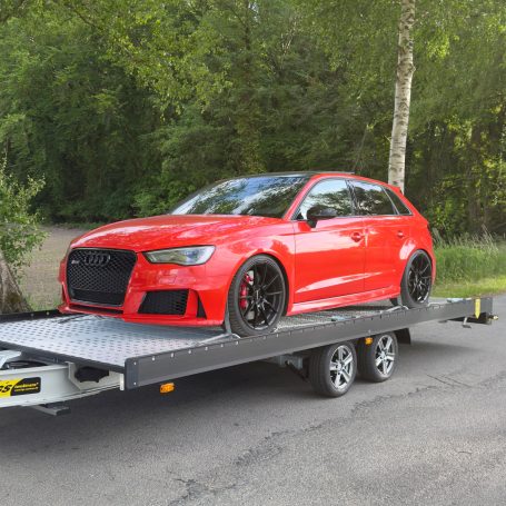 Roter Audi RS3 auf dem Transportanhänger von MHX Fahrzeugtransporte aus Gütersloh