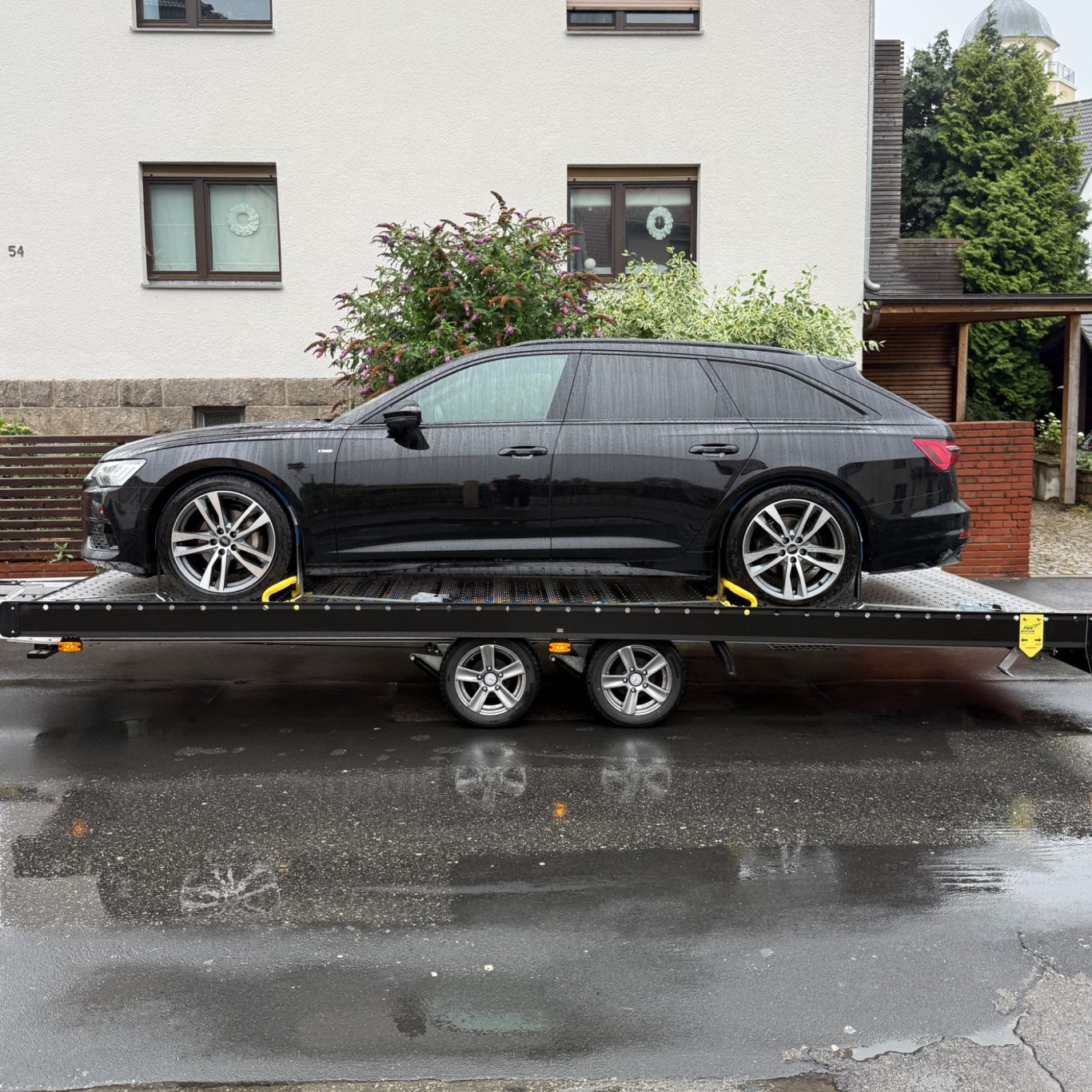 Transport eines schwarzen Audi A6 Avant durch MHX Fahrzeugtransporte aus Gütersloh