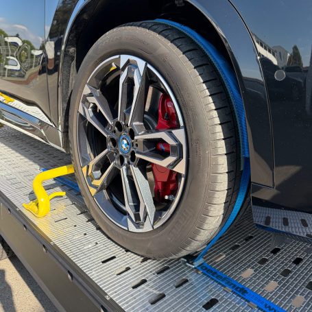 Detailaufnahme des Rades eines BMW iX1 auf dem Anhänger von MHX Fahrzeugtransporte