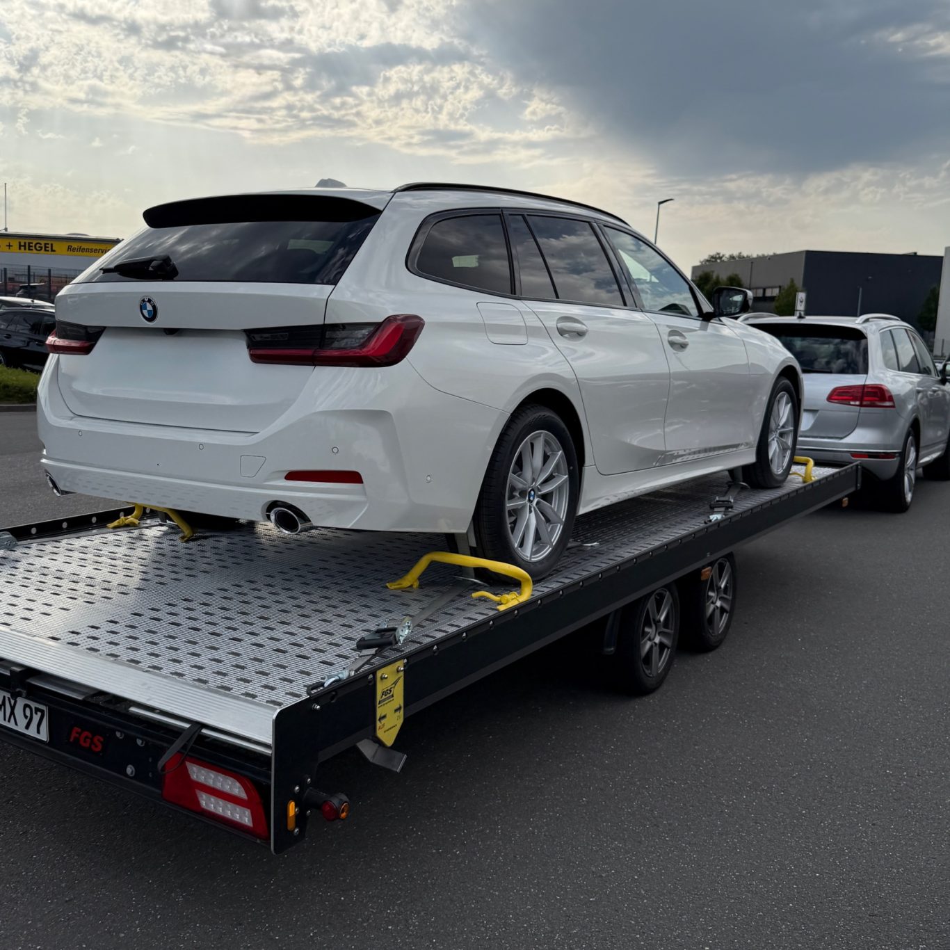 Transport eines weißen BMW Touring durch MHX Fahrzeugtransporte aus Gütersloh