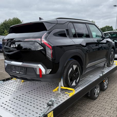 Heckansicht eines schwarzen Kia EV3 auf dem Transportanhänger von MHX Fahrzeugtransporte