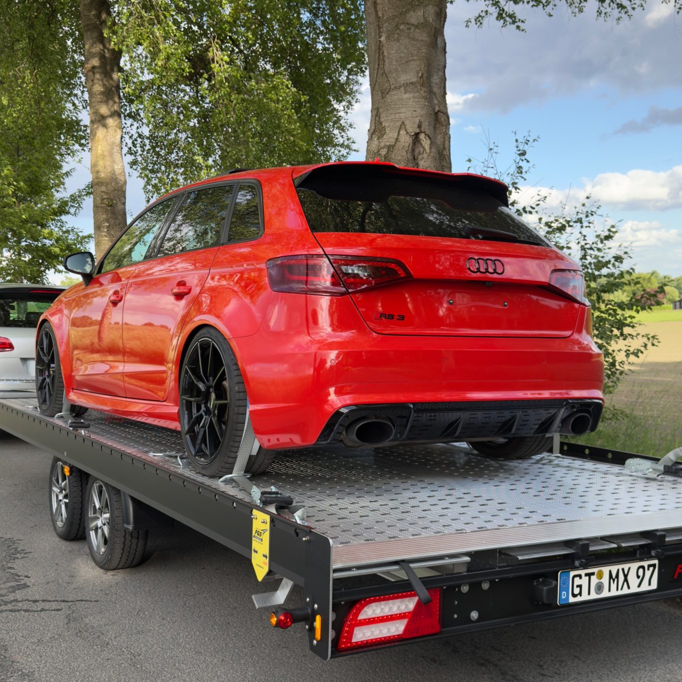 Sportwagentransport eines roten Audi RS3 durch MHX Fahrzeugtransporte aus Gütersloh
