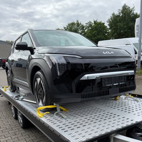Frontansicht eines schwarzen Kia EV3 auf dem Transportanhänger von MHX Fahrzeugtransporte aus Gütersloh